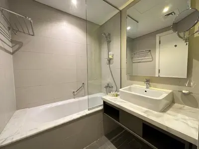 a bathroom with a sink and a shower and a tub at Business Bay Modern studio with a Canal view at DAMAC Maison Prive 1616 in Dubai