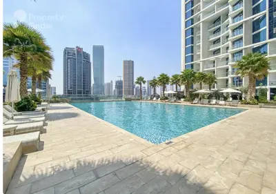 a swimming pool with palm trees and buildings at Business Bay Modern studio with a Canal view at DAMAC Maison Prive 1616 in Dubai