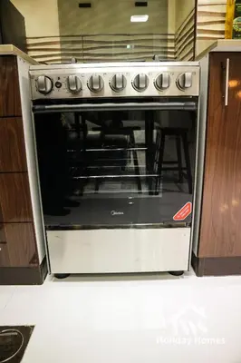 a oven in a kitchen with its door open at The Urban Oasis - Bliss in Dubai