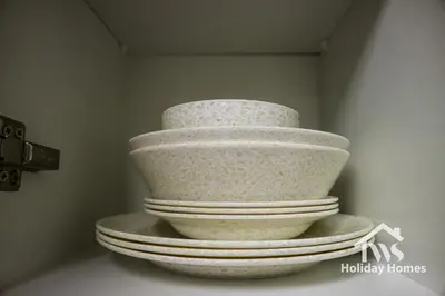a stack of white bowls sitting on a shelf at The Urban Oasis - Bliss in Dubai