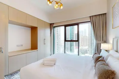 a bedroom with a large white bed with a large window at Burj Royale - Classic One Bedroom in Dubai