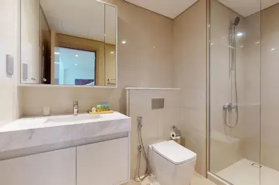 a bathroom with a toilet and a shower and a sink at Burj Royale - Classic One Bedroom in Dubai