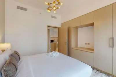 a bedroom with a white bed and a chandelier at Burj Royale - Classic One Bedroom in Dubai