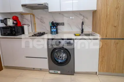a kitchen with a washing machine in a kitchen at Le Petit Village !Cozy Yet Spacious Studio Apartment! in Dubai