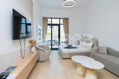 a white living room with a couch and a bed at Le Petit Village !Cozy Yet Spacious Studio Apartment! in Dubai