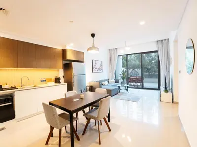 a kitchen and living room with a table and chairs at EasyGo - Exceptional 2BDR- Large Terrace-Pool Access in Dubai