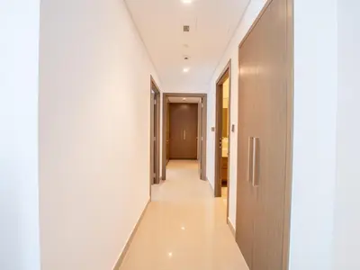 a hallway with white walls and a hallway with wooden doors at EasyGo - Exceptional 2BDR- Large Terrace-Pool Access in Dubai