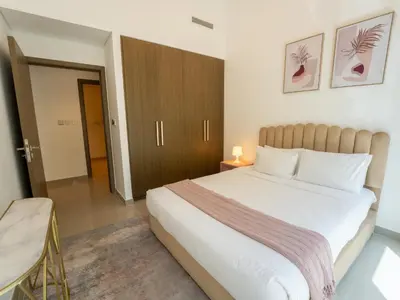 a bedroom with a large white bed and a chair at EasyGo - Exceptional 2BDR- Large Terrace-Pool Access in Dubai