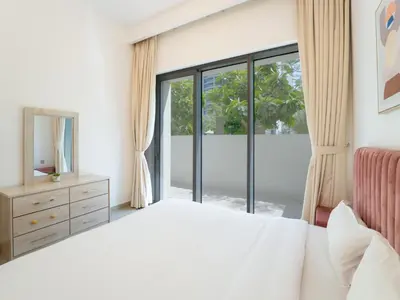 a bedroom with a bed and a large window at EasyGo - Exceptional 2BDR- Large Terrace-Pool Access in Dubai