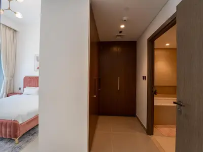 a bedroom with a bed and a door leading to a bathroom at EasyGo - Exceptional 2BDR- Large Terrace-Pool Access in Dubai