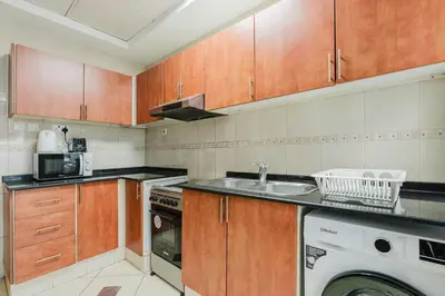 a kitchen with a sink and a washing machine at RH - Spacious & Bright 01BR, Walk away to mall of Emirates in Dubai