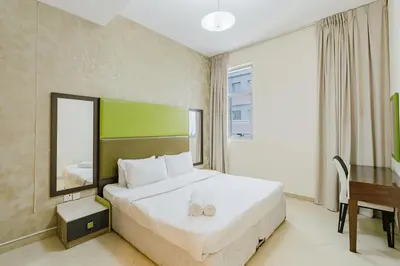 a hotel room with a bed and a desk and a table at RH - Spacious & Bright 01BR, Walk away to mall of Emirates in Dubai