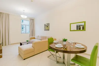 a living room with a table and a couch at RH - Spacious & Bright 01BR, Walk away to mall of Emirates in Dubai