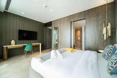a bedroom with a large white bed and a television at Five Palm Super Luxury Apt with Full Sea Views in Dubai