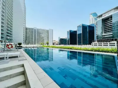 a large swimming pool in a city with tall buildings at Reva tower- 2BR Dubai mall walking & canal facing in Dubai
