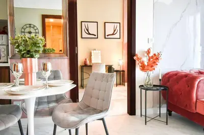 a living room with a table and a red couch at Reva tower- 2BR Dubai mall walking & canal facing in Dubai