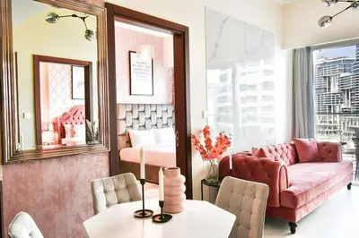 a living room with a pink couch and a table at Reva tower- 2BR Dubai mall walking & canal facing in Dubai
