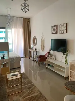 a living room with a flat screen tv and a couch at Spacious Studio Apartment in Dubai Marina with Balcony in Dubai