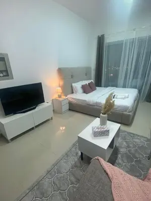 a living room with a couch and a television at Spacious Studio Apartment in Dubai Marina with Balcony in Dubai