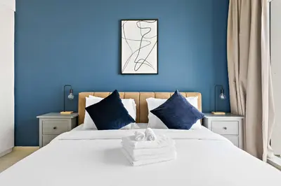a blue bedroom with a bed with blue walls at Silkhaus chic 1BDR in the heart of Downtown in new tower in Dubai