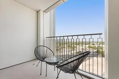 a balcony with two chairs and a glass table at Silkhaus chic 1BDR in the heart of Downtown in new tower in Dubai