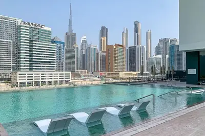 a large swimming pool with white chairs in a city at Frank Porter - 15 Northside Tower 1 in Dubai