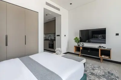a bedroom with a white bed and a flat screen tv at Frank Porter - 15 Northside Tower 1 in Dubai