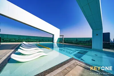 a swimming pool on the roof of a building at Pristine Cozy One Bedroom Suite in Dubai