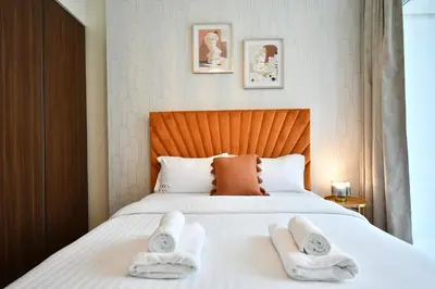 a bedroom with a bed with two towels on it at Vera Residence-Canal Viewing Dubai Mall walking 2BR Chic APT in Dubai