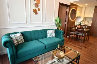a living room with a green couch and a table at Vera Residence-Canal Viewing Dubai Mall walking 2BR Chic APT in Dubai