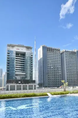 a pool of water in front of a city with tall buildings at Vera Residence-Canal Viewing Dubai Mall walking 2BR Chic APT in Dubai