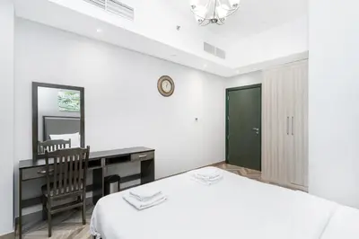 a bedroom with a bed and a desk and a mirror at Spacious 4bd en-suite apt I Canal view I Fast wifi in Dubai