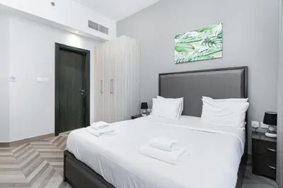a bedroom with a large white bed with two towels on it at Spacious 4bd en-suite apt I Canal view I Fast wifi in Dubai