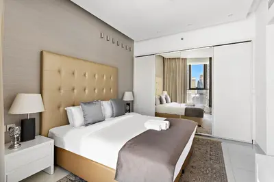 a bedroom with a large white bed and a large window at Chic 1BR Apt with Sofa Bed, Pool & Burj Khalifa View in Dubai