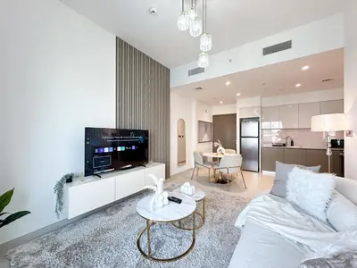 a living room with a couch and a tv at Trophy - Euphoria Eclipse Suite in 29th floor in Burj Royale in Dubai