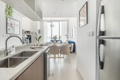 a kitchen with a sink and a dining table at Frank Porter - The Grand in Dubai