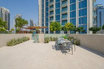 a patio with tables and chairs in front of a building at Frank Porter - The Grand in Dubai