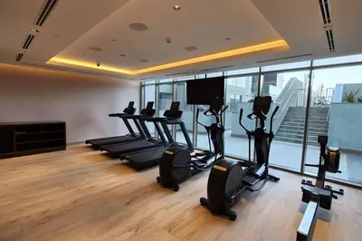 a gym with treadmills and ellipticals in a room with windows at STAY BY LATINEM Luxury 1BR Holiday Home CVR A702 near Burj Khalifa in Dubai