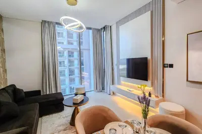 a living room with a couch and a table with chairs at STAY BY LATINEM Luxury 1BR Holiday Home CVR A702 near Burj Khalifa in Dubai
