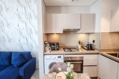 a small kitchen with a blue couch and a stove at STAY BY LATINEM Luxury 1BR Holiday Home CVR A703 near Burj Khalifa in Dubai