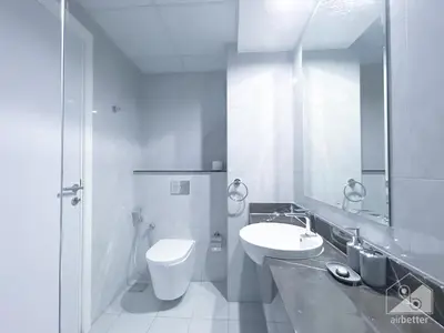 a bathroom with a sink and a toilet and a mirror at Spacious Studio with balcony in AL Majan in Dubai