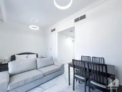 a living room with a couch and two chairs at Spacious Studio with balcony in AL Majan in Dubai