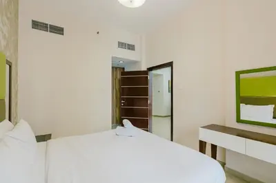 a white bedroom with a white bed and a mirror at RH- Exquisite & Spacious 01 BR, Near Mall of the Emirates in Dubai