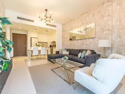 a living room with a couch and a table at Dazzling 1BR in Park Point - Dubai Hills in Dubai