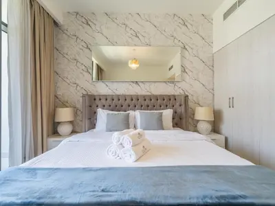 a bedroom with a large bed with a mirror on the wall at Dazzling 1BR in Park Point - Dubai Hills in Dubai