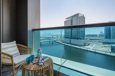 a balcony with a chair and a view of a city at Frank Porter - Damac Voleo in Dubai