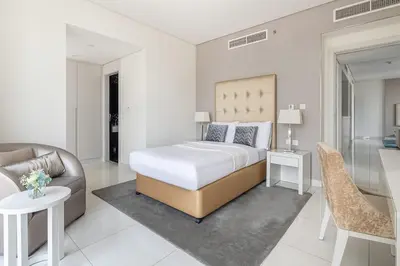 a bedroom with a bed and a living room at Frank Porter - Damac Voleo in Dubai