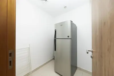 a refrigerator in a room with a white wall at Waterfront With Stunning View! in Dubai