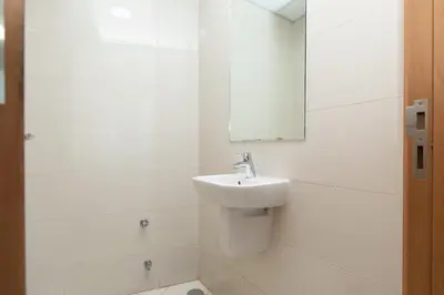 a white bathroom with a sink and a mirror at Waterfront With Stunning View! in Dubai