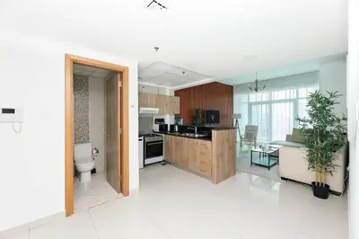 an open kitchen and living room with a plant in it at Waterfront With Stunning View! in Dubai